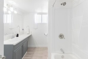A modern bathroom with a double sink vanity, a shower, and a toilet. - Chic 2-Bed Oasis, Sleeps 6! Minutes From Strip! (Las Vegas)