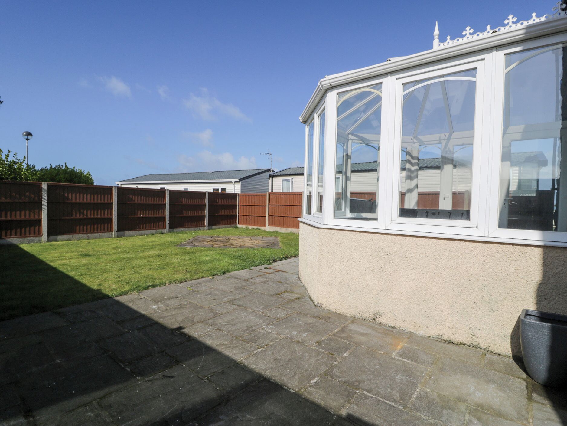 A residential property with a covered patio, a fenced backyard, and a garage.