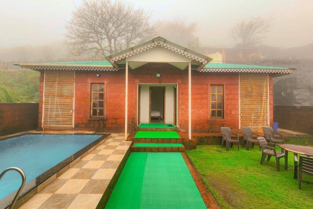 Un bâtiment à deux étages doté d’une piscine, d’un patio couvert et d’un espace salon extérieur.