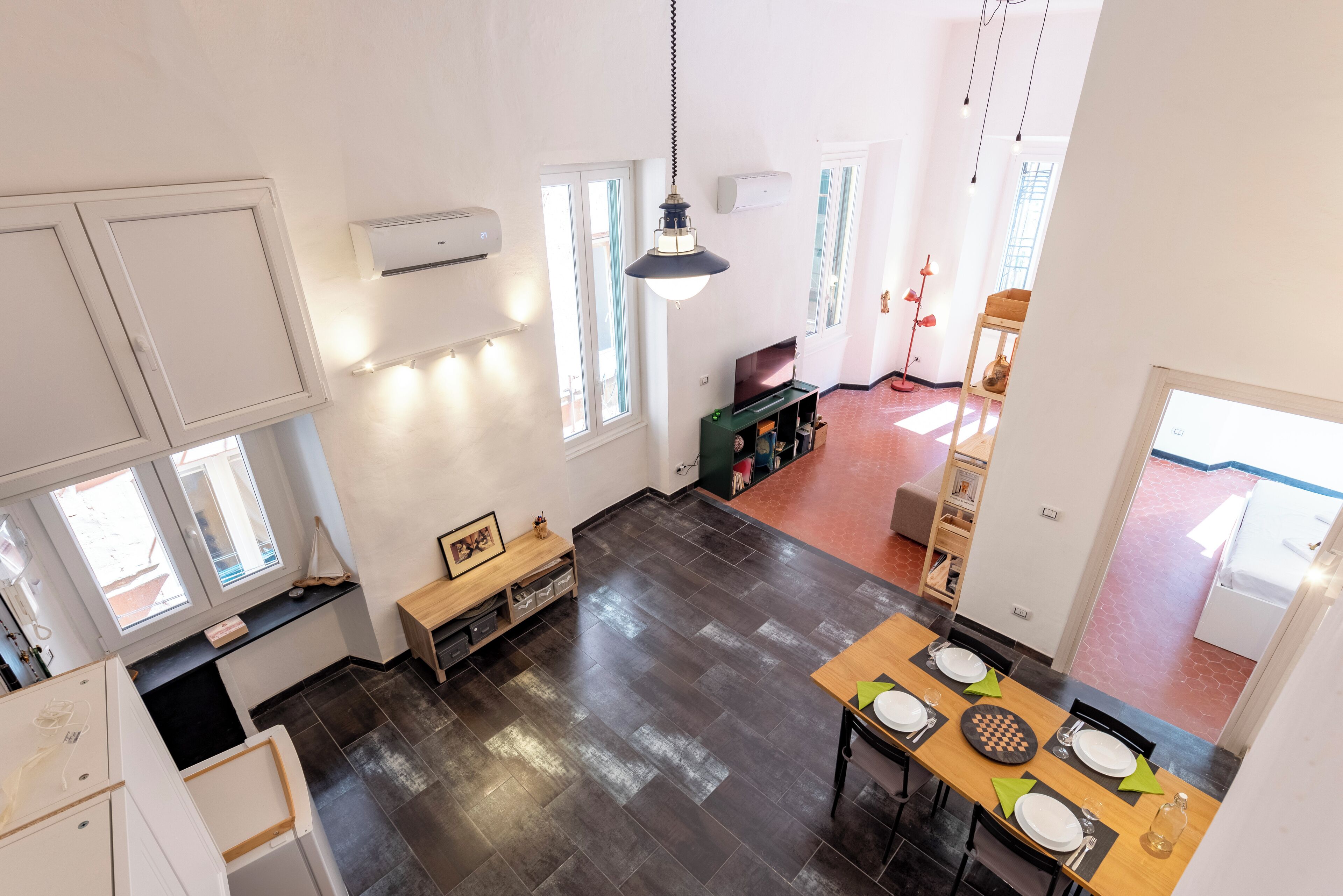 A spacious kitchen with dark flooring, white cabinets, and a dining area with a chessboard.