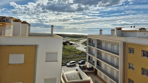 Un edificio residencial con varios balcones y vista al mar.