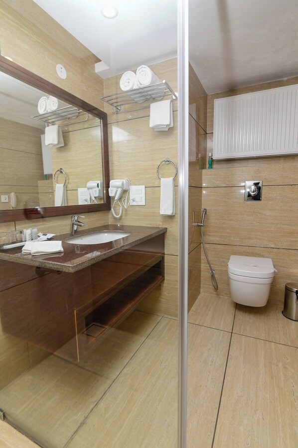 A modern bathroom with a large mirror, two sinks, a shower, and a toilet. - Tsokar Retreat (Leh)