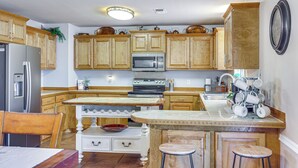 A kitchen with wooden cabinets, a refrigerator, a microwave, and a stove.