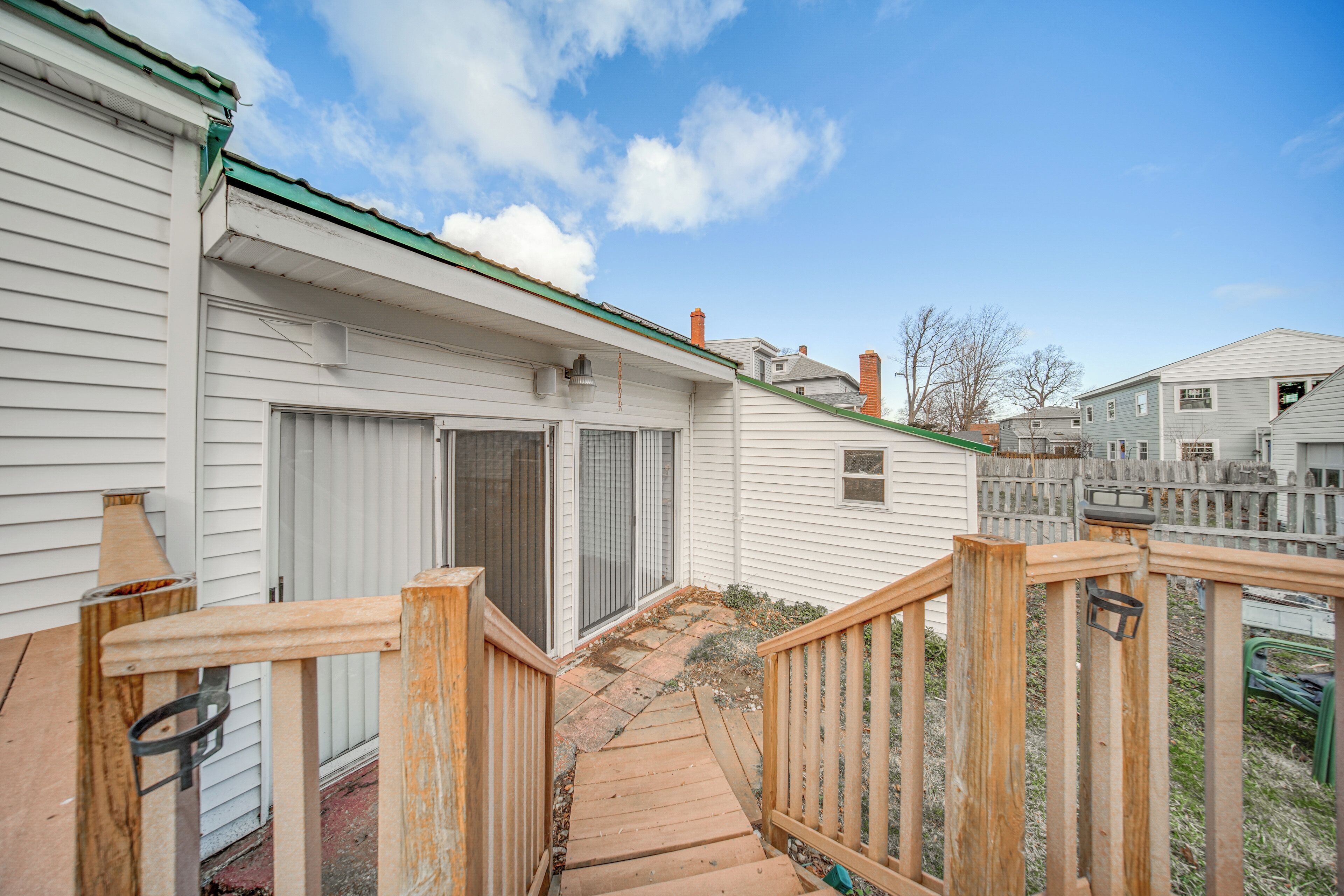 A residential property with a wooden deck, a garage, and a fenced backyard.