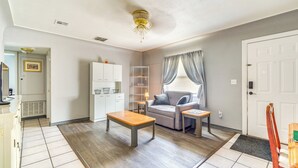 A living room with a sofa, a coffee table, a TV, and a ceiling fan. - Boat, Hike, & Golf: Inviting Inverness Getaway! (Inverness)