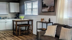Ein Wohnzimmer mit Couch, Esstisch und Stühlen sowie einem Holztisch.