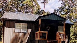 Eine rustikale Holzhütte mit Metallverkleidung und einer Veranda mit Holzgeländern.