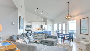Ein geräumiges Wohnzimmer mit einer großen Eckcouch, einem Essbereich mit Holztisch und Stühlen sowie einer Küche im Hintergrund.
