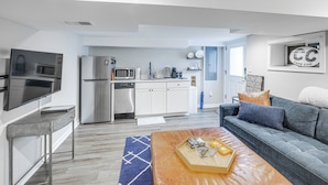 A modern apartment with a kitchen, living area, and a sofa. - Walkable Location: Modern DC Apt w/ Yard Access! (Washington)
