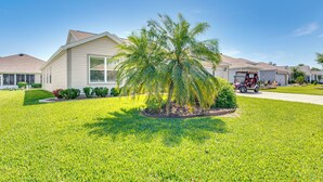 A residential house with a well-maintained lawn, a palm tree, and a fire truck parked in the driveway. - 2 Mi to Lake Sumter Landing: Spacious Golf Retreat (The Villages)