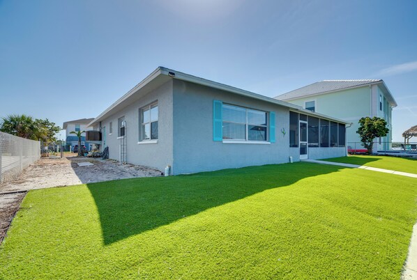A modern two-story house with a well-maintained lawn and a clear sky. - Canal & Gulf Views: Spacious Hudson Home (Hudson)