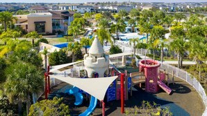 A playground with a slide, climbing structures, and a white tower. - Solara Resort Home w Pool 15 min to Disney World (Kissimmee)