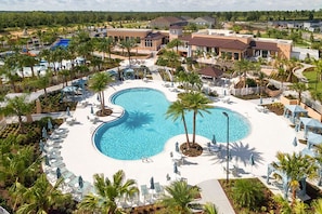 A resort with a large central pool, surrounded by palm trees and lounge chairs. - Solara Resort Home w Pool 15 min to Disney World (Kissimmee)