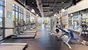 A gym with treadmills, weight machines, and free weights. - Solara Resort Home w Pool 15 min to Disney World (Kissimmee)