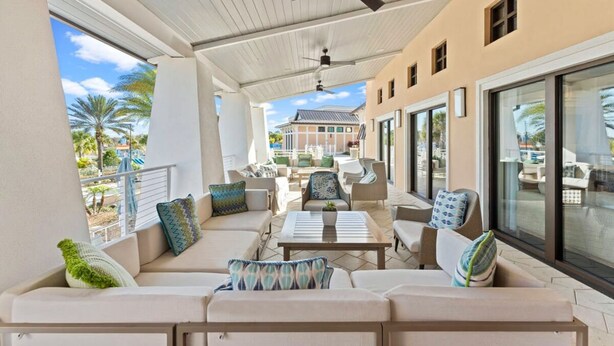 A covered outdoor seating area with sofas, chairs, and a ceiling fan. - Solara Resort Home w Pool 15 min to Disney World (Kissimmee)