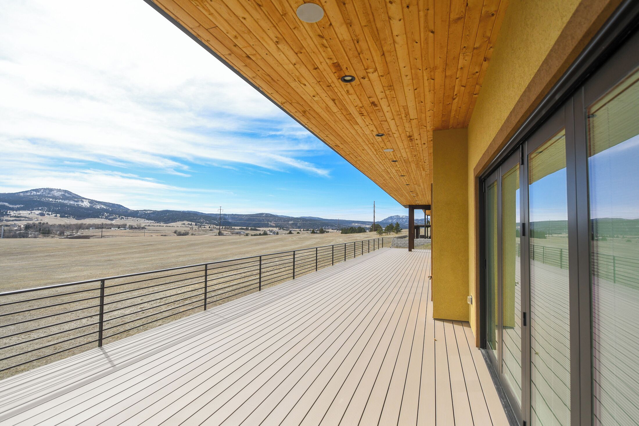 Una terraza de madera con vistas a un paisaje montañoso.