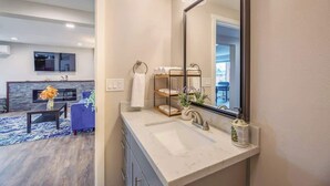 Une salle de bain moderne avec un grand miroir, un lavabo et un porte-serviettes.