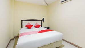 A neatly made bed with a white and red bedspread, a wooden headboard, and a red throw at the foot of the bed. - Hotel O Bekasi Near Mall Lippo Cikarang Formerly Hotel Addictk (Cikarang)