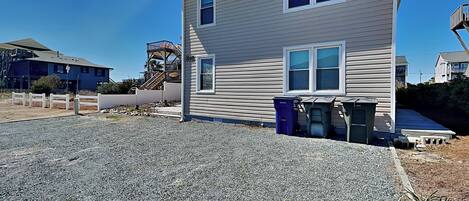 A two-story house with a gravel driveway and a fenced yard.