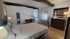 Une chambre à coucher avec un grand lit, une commode, un bureau et un miroir.