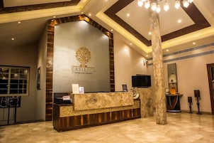 A reception desk with a logo, a TV, and a mirror.
