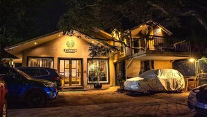 A two-story building with a sign reading "BASILICA MEDICINE CENTRE". There are cars parked in front and a covered object on the ground. - Basilica Resort - Where Luxury Redefines (Panchgani)