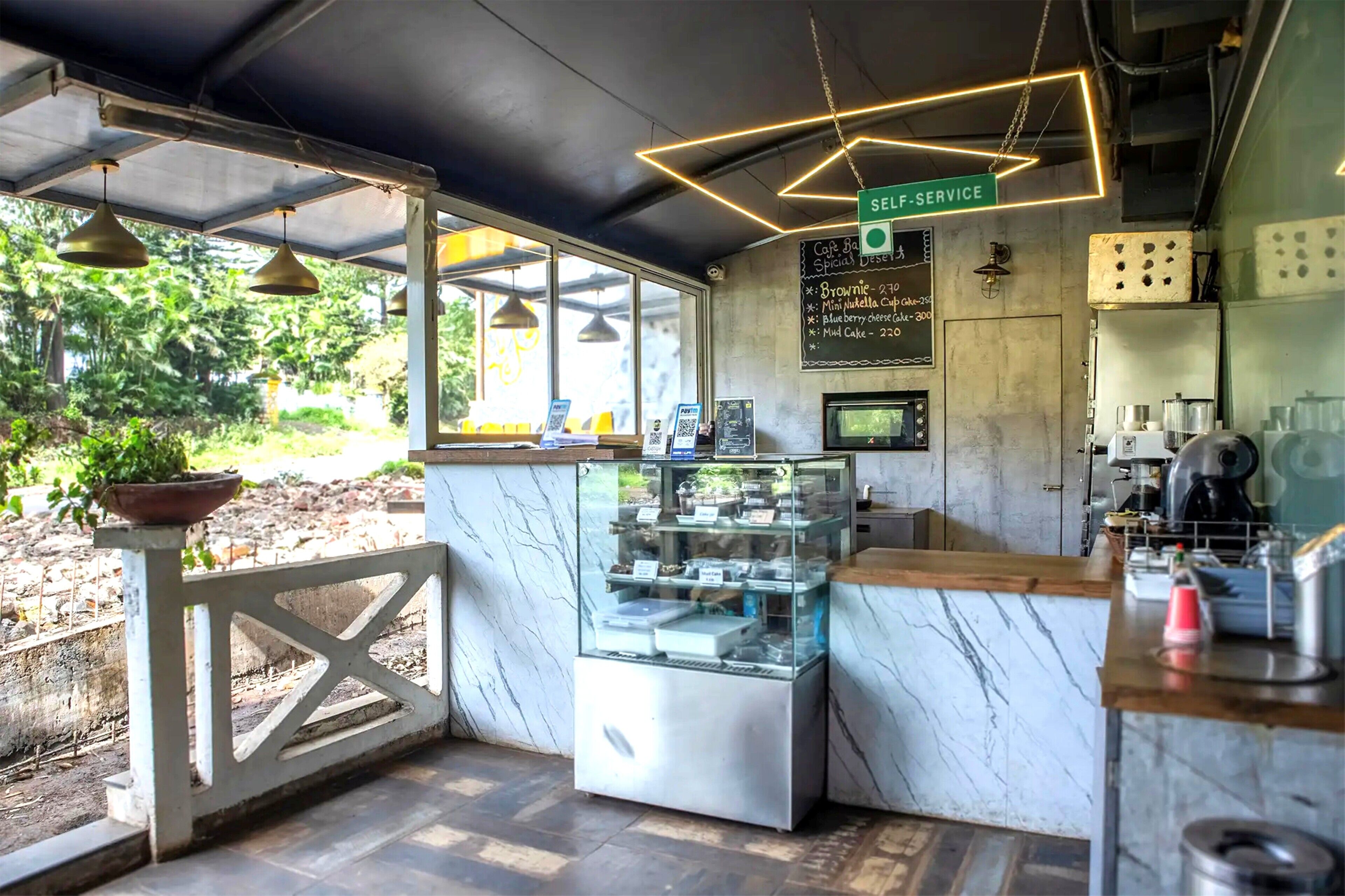 A cafe with a self-service counter, menu board, and a display case.