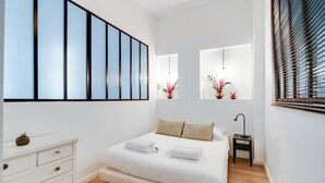 Une chambre à coucher moderne avec un grand lit, une commode et une table de chevet.