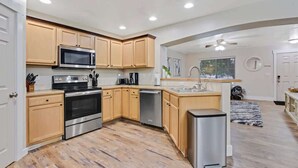 Una cucina moderna con mobili in legno, elettrodomestici in acciaio inossidabile e lavastoviglie integrata.
