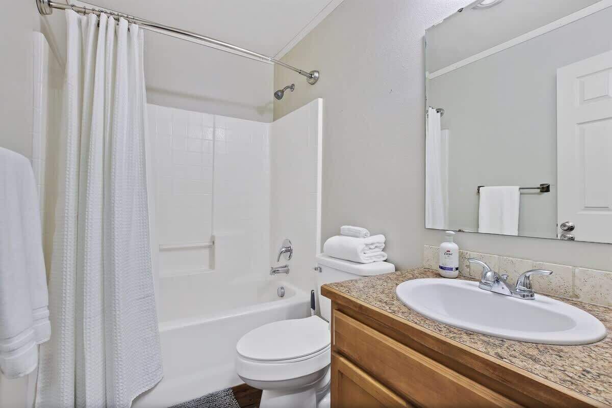 A bathroom with a bathtub, toilet, and sink.