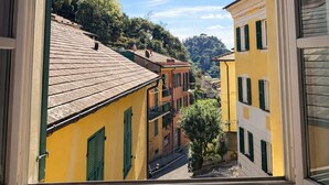 A window view of a narrow street with buildings, a tree, and a clear sky. - Charming Portofino 3-bed retreat (Portofino)