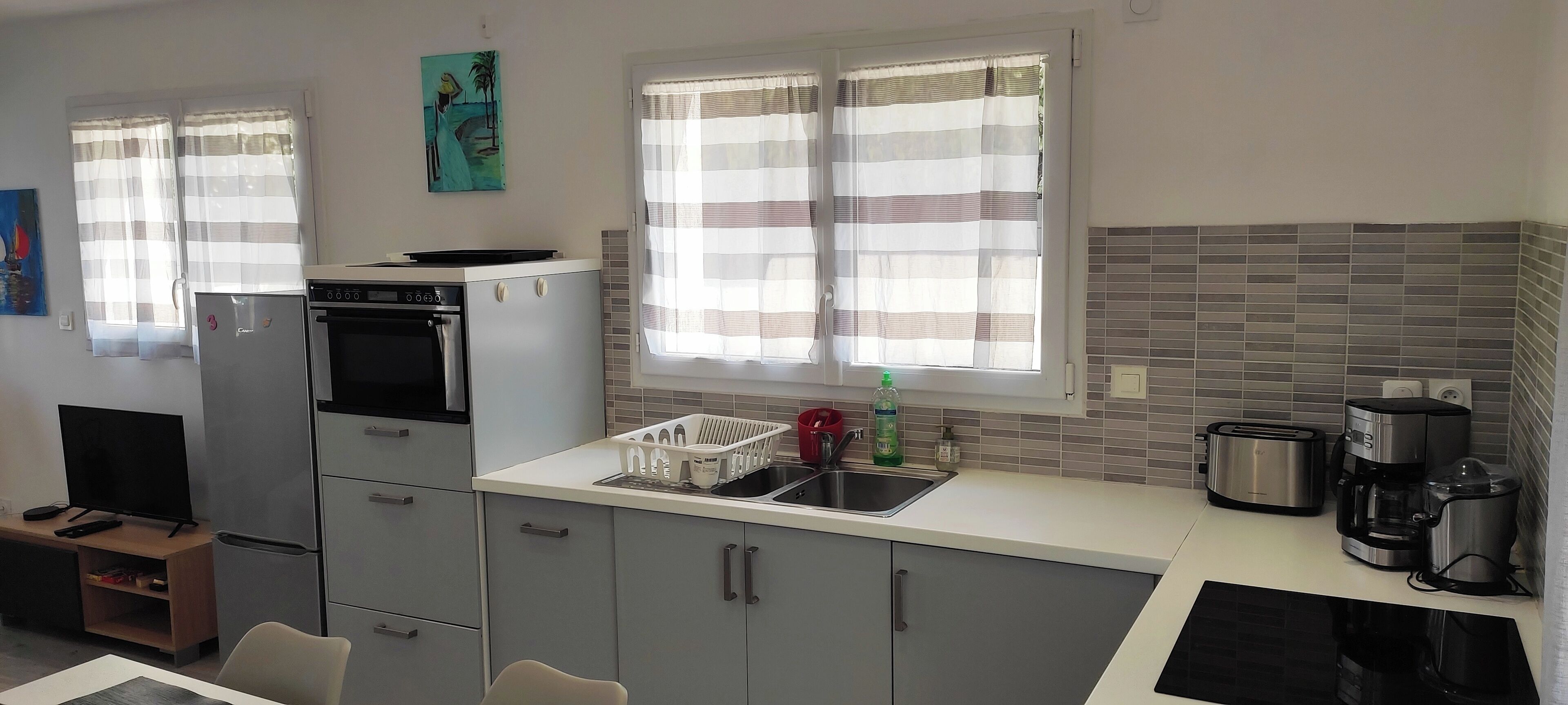 A compact kitchen with a refrigerator, oven, and a coffee maker.