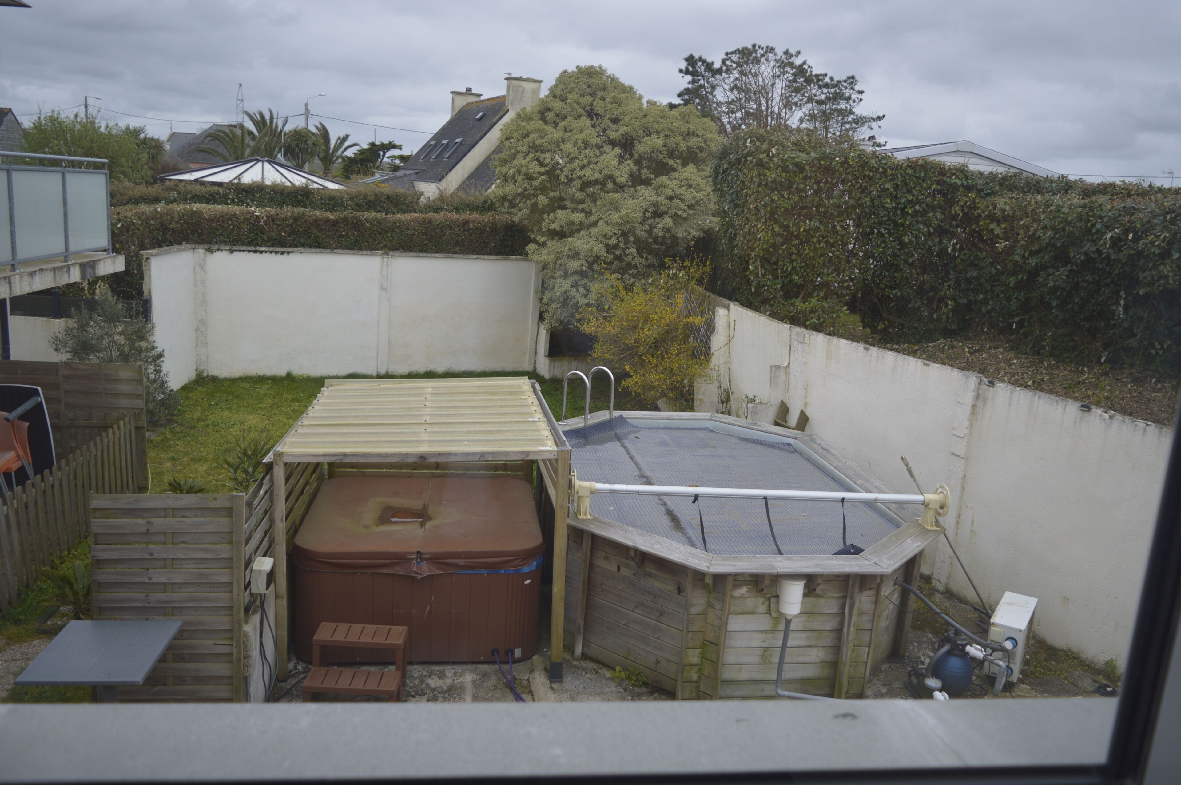 Un jardin avec un jacuzzi, une petite terrasse et une piscine.