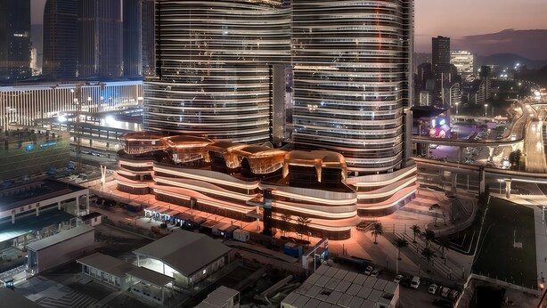 Un hôtel moderne à la façade incurvée, doté de plusieurs étages et d’un hall d’entrée imposant.