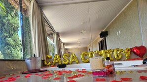 Ein Zimmer mit einem Tisch, dekoriert mit Rosenblättern und goldenen Ballons, die "CASA CANTINA" buchstabieren.