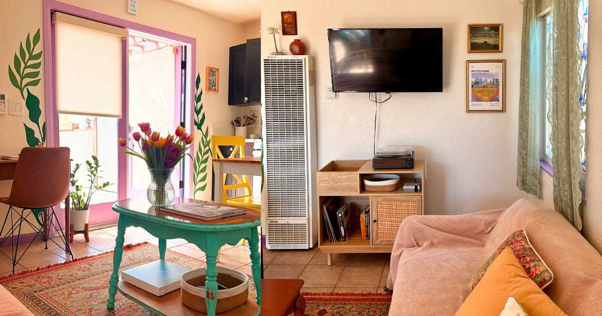 Un salon comprenant un canapé, un téléviseur fixé au mur, une table avec un vase de fleurs et un grand climatiseur.