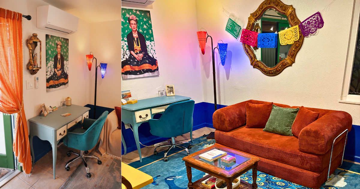A room with a desk, a blue chair, a red sofa, and a coffee table.
