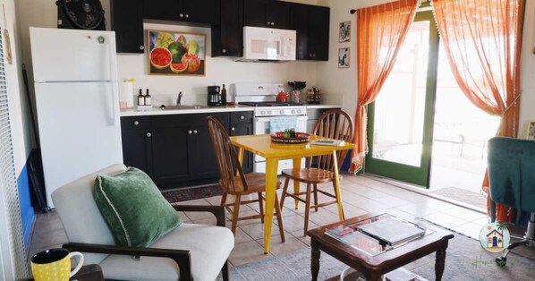 A compact living space with a kitchenette, a dining area, and a seating area.