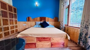 Ein Zimmer mit einem Bett, Holzwandverkleidung, einem fenster mit Vorhängen und einer Wandleuchte.