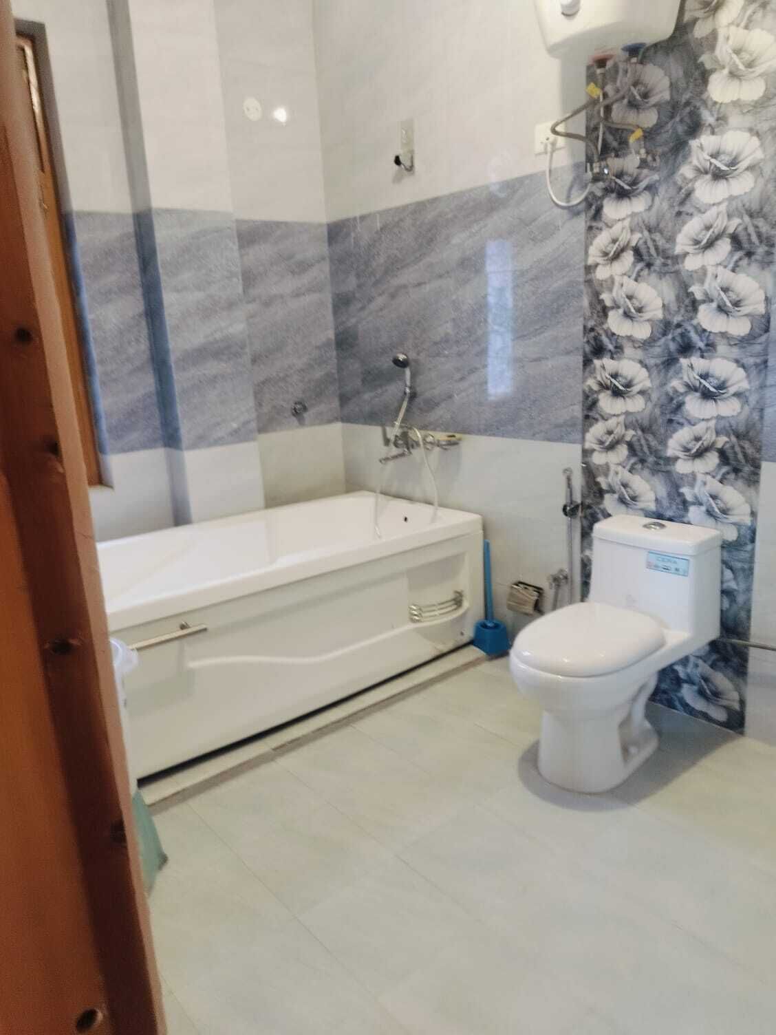 A bathroom with a bathtub, toilet, and shower.