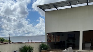 An outdoor seating area with lounge chairs and a view of the sea. - Mais Hotel (Araguaina)