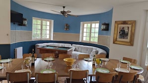 Un comedor con mesa de billar, sofá y ventilador de techo.