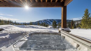 A hot tub in a snowy outdoor setting with a mountain view. - Silver Aspen | Fire Pit, Hot Tub & Views (Big Sky)