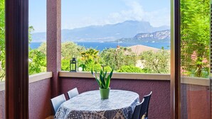 A balcony with a table, chairs, and a potted plant. - Regarda -Blue View 3  Apartment with lake view and pool (Bardolino)
