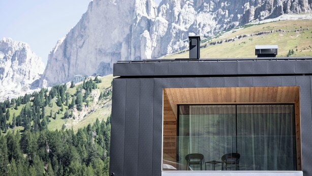 A modern building with a large window and a view of a mountainous landscape.