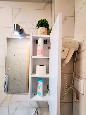 Regadera, secadora de cabello, toallas, papel de baño