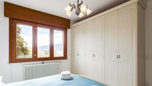 A bedroom with a bed, a large wardrobe, and a window with a view. - Regarda - La Terrazza di Garda lake view apartment with terrace (Garda)