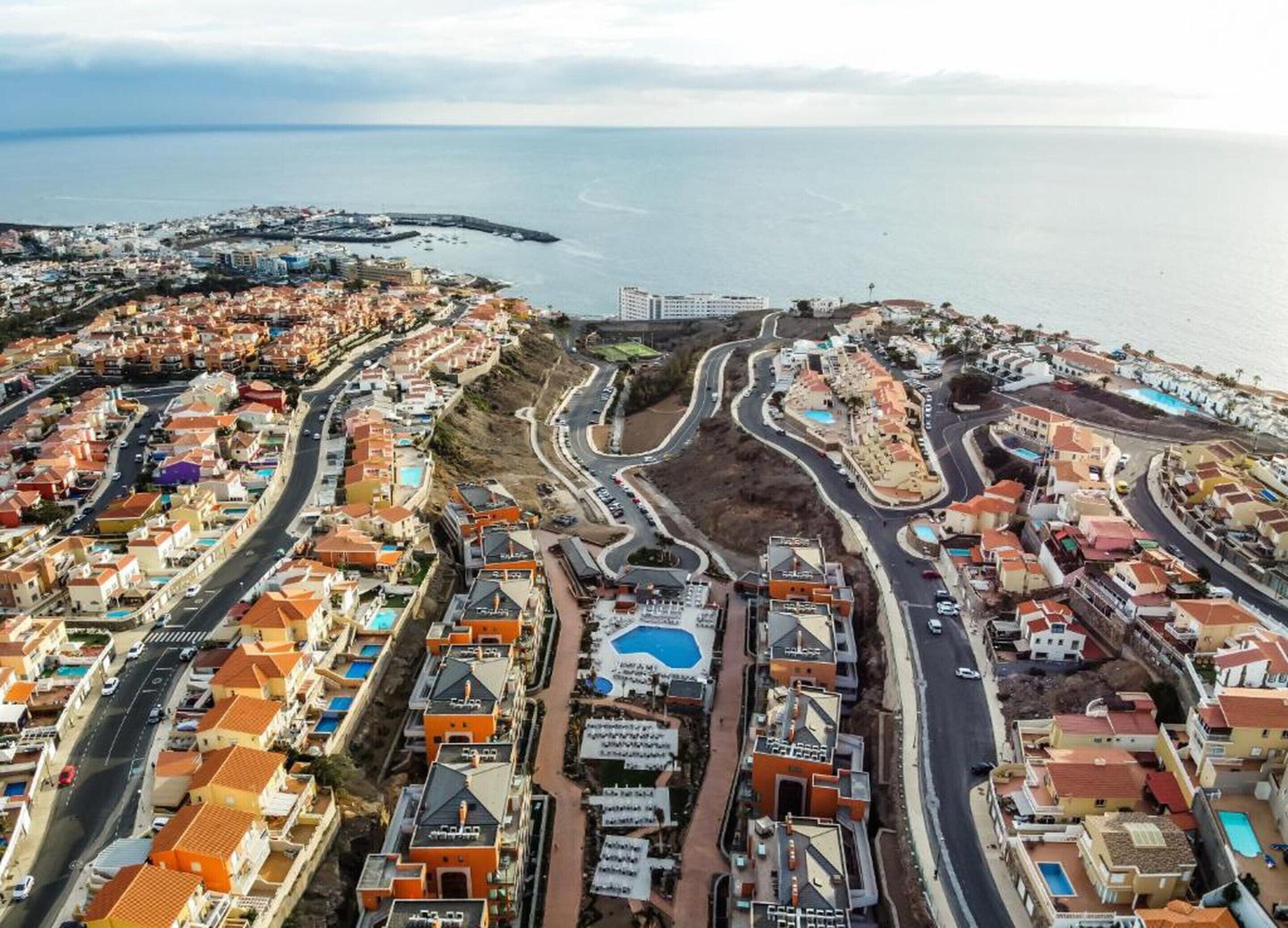 Zona residencial costera con casas, calles y un puerto deportivo.