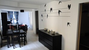 Ein moderner Essbereich mit einem schwarzen Esstisch-Set und einer an der Wand befestigten Vogeldekoration.
