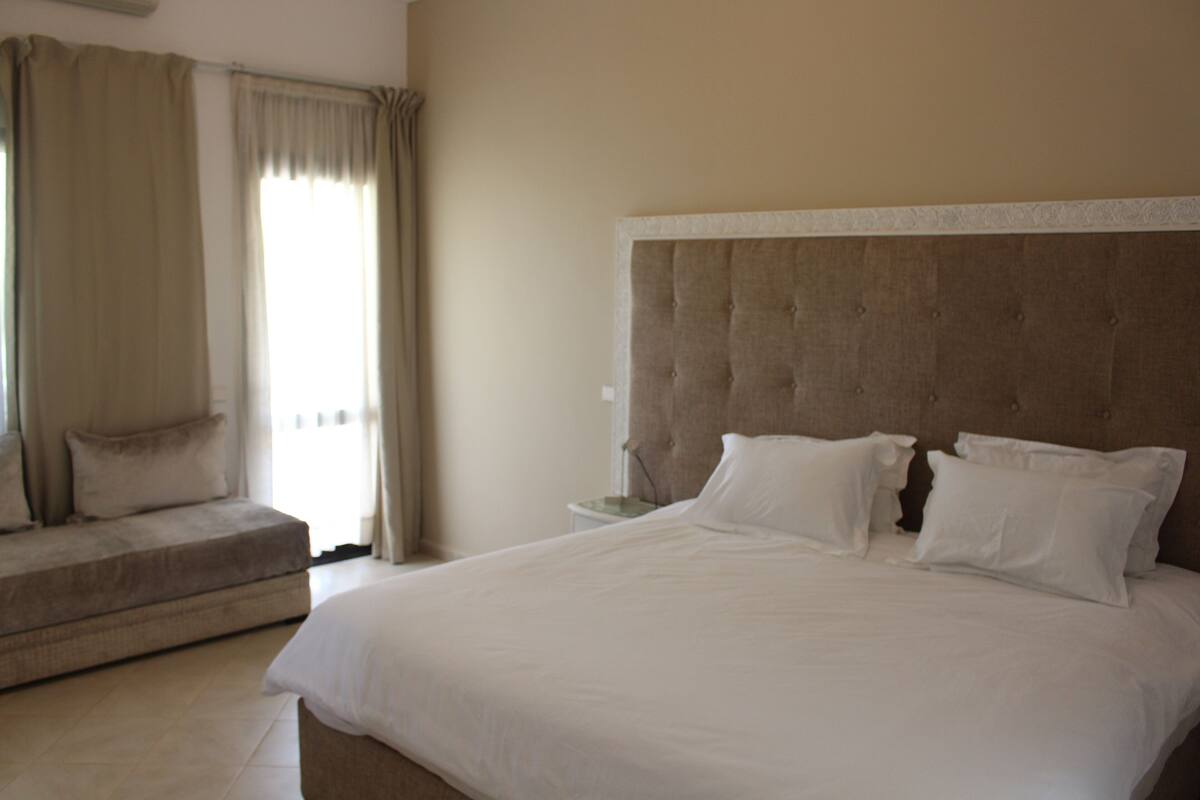 Une chambre d’hôtel avec un grand lit, un canapé et une table de chevet.